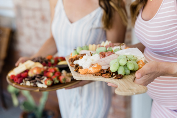 galentines day women holding charcuterie trays for Galentine's Day
